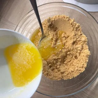 Geschmolzene Butter auf feinen Keksbröseln