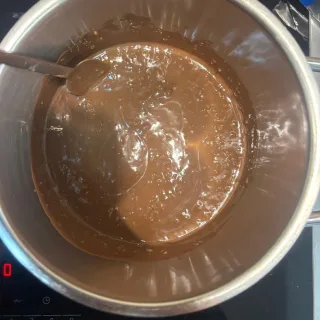 Glänzende Haselnussschokolade schmilzt mit kleinen Stücken